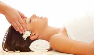 Young attractive girl receiving head massage at spa resort